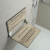 Faux weathered teak shower seat folds up when not in use